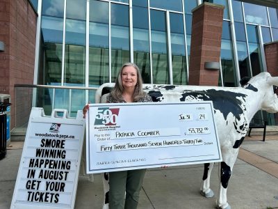 photo of winner Patricia Coomber holding a large cheque for $53,732.