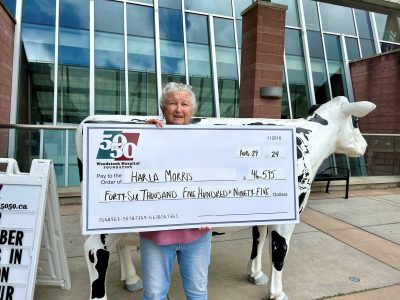 Photo of winner Harla Morris holding a large cheque for $46,595