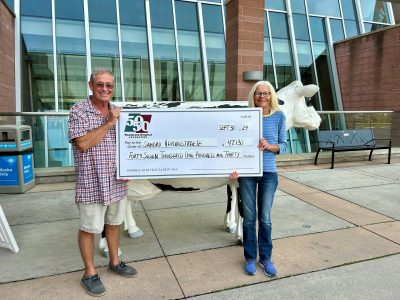 Photo of Sandra Verougstaete with her husband Ron. They are holding a large cheque for $47,130 in front of the hospital.