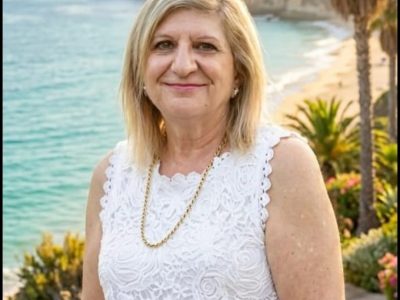 Anna standing for a photo with a beach background