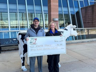 GP Winner Photo Jennifer and her husband standing holding her cheque in front of the hospital